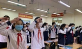 Học sinh Trường THCS Mai Đình, Sóc Sơn (Hà Nội) chào cờ trong buổi học đầu tiên. 