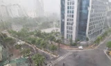 Mưa to gió lớn khiến người đi xe máy không thể di chuyển ở đoạn đường gần khu Đại sứ quán Mỹ thuê