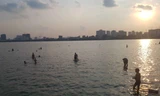 Người dân đổ ra Hồ Tây tắm, mặc cá chết bốc mùi tanh nồng ​