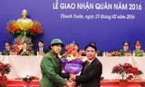 Chủ tịch UBND quận Thanh Xuân Nguyễn Xuân Lưu tặng hoa cho tân binh Ngô Quang Huy tại lễ giao, nhận quân. (Ảnh: Hồng Thái).
