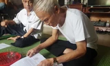 Ông Nguyễn Thái Tưởng lật giở từng trang giấy kể lại chuyện 40 năm của xóm 