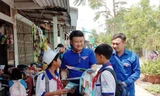 Anh Trần Quốc Bủ, Bí thư Đoàn xã Đất Mới (thứ hai, từ trái sang) phát tờ rơi phòng chống đuối nước cho các em học sinh 