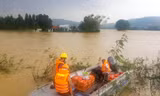 Công an huyện Tuy Phước dùng ca nô để hỗ trợ lương thực cho người dân bị nước lũ cô lập. Ảnh: Trương Định