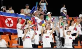 Những người ủng hộ Triều Tiên cổ vũ trong trận đấu bóng đá nam giữa Kyrgyzstan và Triều Tiên tại Đại hội thể thao châu Á tại sân vận động Kim Hoa, Trung Quốc, ngày 21/9. (Ảnh: Yonhap)
