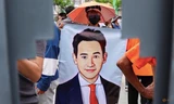 Một người ủng hộ cầm banner in phác hoạ chân dung lãnh đạo đảng Tiến bước Pita Limjaroenrat ở Bangkok ngày 19/7. (Ảnh: Reuters)