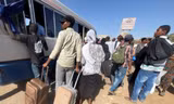 Người dân lên xe buýt rời khỏi thủ đô Khartoum. (Ảnh: Reuters)