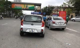 Taxi che biển số, đỗ tràn dưới lòng đường, trước cổng Bệnh viện Bạch Mai chèo kéo khách.