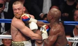 Conor McGregor (trái) dính một đòn nặng từ Mayweather.