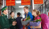 Đại diện Đồn Biên phòng Cửa khẩu Quốc tế Lao Bảo tặng hoa cho hai vị khách quốc tế đầu tiên nhập cảnh bằng thị thực điện tử qua đường bộ. 