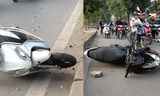 Hai chiếc xe máy đổ ra đường sau khi bị chiếc ôtô đâm phải.