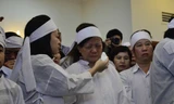 Con gái ông Nguyễn Bá Thanh lau nước mắt cho mẹ trong giờ truy điệu sáng 16/2.