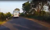 Chiếc xe khách lấn hết phần đường khiến xe máy phải lao lên lề, tông vào biển báo giao thông. Ảnh cắt từ clip