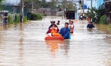 Dùng phao giúp phụ nữ chạy lũ