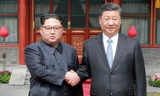 Lãnh đạo Triều Tiên Kim Jong Un bắt tay Chủ tịch Trung Quốc Tập Cận Bình trong chuyến công du Bắc Kinh hồi tháng 3/2018. Ảnh: SCMP