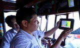 Cán bộ ngành thủy sản kiểm tra thiết bị giám sát hành trình khai thác trên tàu cá trước khi ra khơi, tại cảng cá Quy Nhơn, thành phố Quy Nhơn, tỉnh Bình Định. Ảnh: TTXVN