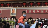 Một bé trai ngồi trên cổ bố khi đi chơi ở quảng trường Thiên An Môn ngày 3/5. Ảnh: AP 