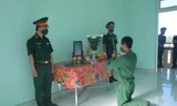 Binh nhì Nguyễn Huy Hoàng vọng bái mẹ trước bàn thờ được lập trong đơn vị. (Ảnh: B.N)