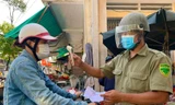 Người dân trước khi vào chợ đều phải xuất trình phiếu và được đo thân nhiệt. Ảnh: Nguyễn Ngọc