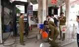 Lực lượng chức năng kiểm tra cây xăng gian lận.