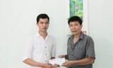 Nhà báo Trần Tuấn - Trưởng VP đại diện miền Trung (báo Tiền Phong) trao quà của bạn đọc giúp đỡ em Nguyễn Văn Sỹ (bên trái).