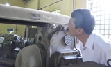 Trưởng khoa Cơ điện, Học viện Nông nghiệp Việt Nam Lê Minh Lư (SN 1961) bên một cỗ máy có tuổi đời ngang bằng với số tuổi của ông. Ảnh: HB