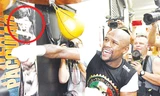 Mayweather tập luyện bên tấm poster có hình đối thủ Pacquiao của anh bị bịt mắt, bịt miệng bằng băng keo. Ảnh: Getty Images