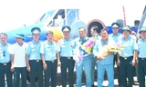 Đồng đội chúc mừng đại tá Lê Kiêm Toàn và thượng tá Nguyễn Đức Hảo (hai người cầm hoa) trở về đơn vị sau khi thực hiện nhiệm vụ bay chuyển sân hạ cánh ở Trường Sa trên một chiếc Casa-212, đầu tháng 6/2016.