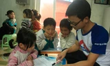 Các tình nguyện viên của dự án Help to Fly đang dạy tiếng Anh cho trẻ em nghèo làng chài Ngọc Sơn (Kiến An, Hải Phòng). Ảnh: Thúy An