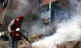 Nhân viên y tế Venezuela đang phun thuốc diệt muỗi Aedes truyền virus Zika ở khu dân cư. Ảnh: Xinhua