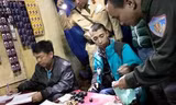 Nam thanh niên mặc áo khoác xanh, cùng các tang vật ở trên bàn liên quan đến hành vi mua bán chất ma túy bị công an bắt quả tang. Ảnh: Công an Huế