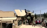 Tay súng Taliban đứng trên nóc xe Humvee của Mỹ ở Kabul. Ảnh: Reuters