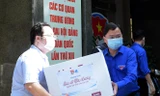 Anh Nguyễn Anh Tuấn và các đoàn viên thanh niên chuyển các thùng quà lên xe đến với các vùng dịch. Ảnh: Xuân Tùng