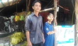 Anh Trương Văn Lợi và con trai bên túp lều lụp xụp.