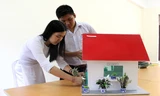 Quánh Đức Huy và Trần Mỹ Duyên với mô hình ngôi nhà giảm thiểu ô nhiễm môi trường cho khu dân cư lân cận bãi rác Khánh Sơn. Ảnh: Đào Phan.