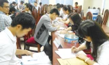 Các học viên cao học và nghiên cứu sinh làm thủ tục nhập học.