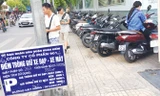 Bảng niêm yết giá công khai, nhưng chiều qua nhân viên điểm trông xe tại vỉa hè phố Hàng Bài vẫn thu giá gần gấp đôi quy định. Ảnh: AT.