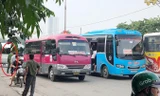 Xe khách dàn hàng ngang bắt khách trên đường nhưng một cán bộ công an (vòng tròn) làm việc tại cổng bến Giáp Bát sáng 20/8 chỉ đứng nhìn.