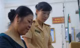 Trung tá Hứa Thị Ánh Tuyết hướng dẫn người dân làm thủ tục cấp giấy tờ đăng ký xe.