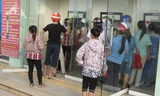 Lẫn trong dòng người xếp hàng, có nhiều chủ tiệm cầm đồ cầm thẻ ATM của công nhân đi rút tiền. Ảnh: Quỳnh Nga. 
