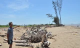 Ông Danh Văn Mỡ ở ấp Hồ Thùng, xã Đông Hải, (Duyên Hải, Trà Vinh) chỉ trên bãi cát đã cuốn mất nhà và hàng dương. Ảnh: Hòa Hội.