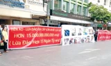Người dân treo băng rôn tố cáo công ty lừa đảo tiền ảo. Ảnh: PV.