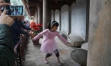 Một số phụ huynh vẫn xui con trẻ vượt rào vào sờ đầu rùa ở Văn Miếu. Ảnh: Nguyên Khánh.