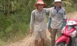 Ông Nguyễn Văn Nam (bìa phải) ở xã Mỹ Hòa và ông Phạm văn Hở ở xã Mỹ Nhơn đang mót rơm phơi trên đường. Ảnh: Thanh Phong.