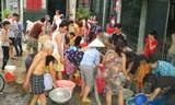 Người dân ở ngõ 243 Giáp Bát - Hà Nội đi lấy nước sạch của Cty Viwaco cung ứng nước vào ngày 23/5/2014. Ảnh: Như Ý.