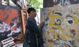 Họa sĩ Trần Thị Thu bên tác phẩm của mình.