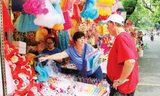 Du khách nước ngoài mua đồ chơi Tết Trung thu tại phố Hàng Mã. Ảnh: Quang Lộc.