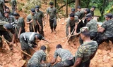 Binh lính Sri Lanka dùng xẻng đào bùn đất để tìm các nạn nhân. Ảnh: Guardian.