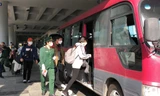 Hành khách lên xe đến địa điểm cách ly sau khi xuống sân bay Cần Thơ. Ảnh: KIM HÀ 