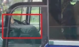 Tài xế xe khách dùng chân điều khiển xe đã bị người đi đường ghi lại clip. Ảnh cắt từ clip.