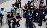  Cảnh sát Hồng Kông khiêng từng sinh viên ra khỏi trụ sở chính quyền - Ảnh: Reuters 